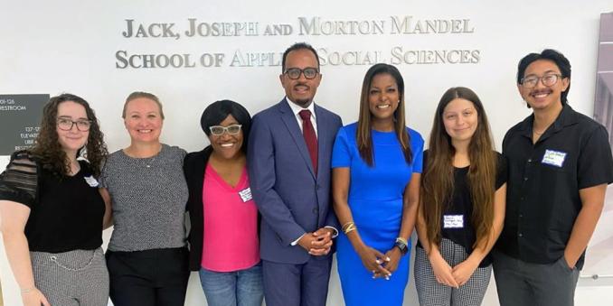 Lori Stokes and Dexter Voisin with students in the Mandel School building