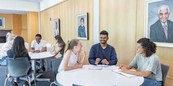 Two tables of students in Mandel Center talking