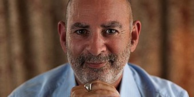 Howard Guttman sitting with his head on his hands headshot