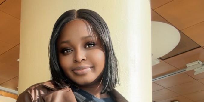 Damilola Ayetan stands with her hands in her coat pockets and smiles