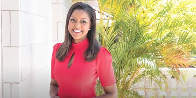Lori Stokes smiles in front of some plants