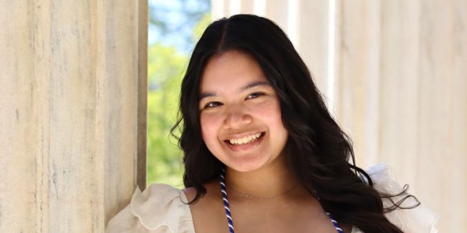 Elena Cangahuala holding her mortar board