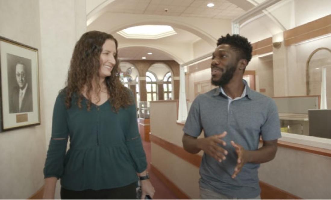 A women and man discussing in a hallway