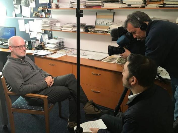 Image of Dr. Daniel J. Flannery being interviewed by News 5 Cleveland, sitting in chair in his office on left of image, with reporter and cameraman on right