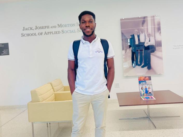 BeBernard Oteng standing in the front entrance of the Mandel School