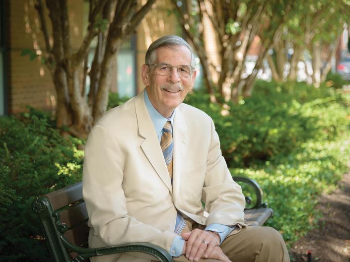 Terry Hokenstad sits on a bench outside the Mandel School