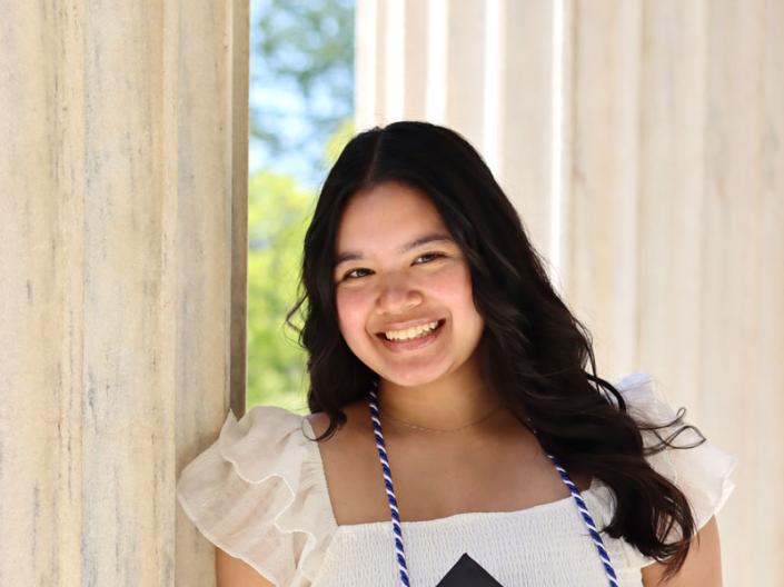 Elena Cangahuala holding her mortar board
