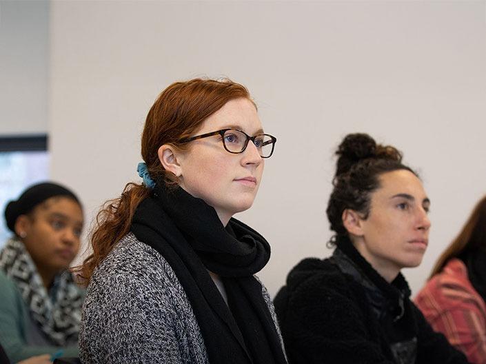 Three students sitting at desk during a lecture