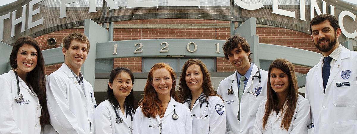 A group of student doctors standing in front of the clinic.