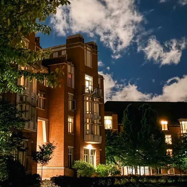 A well-lit building in the Village at CWRU at nightime.