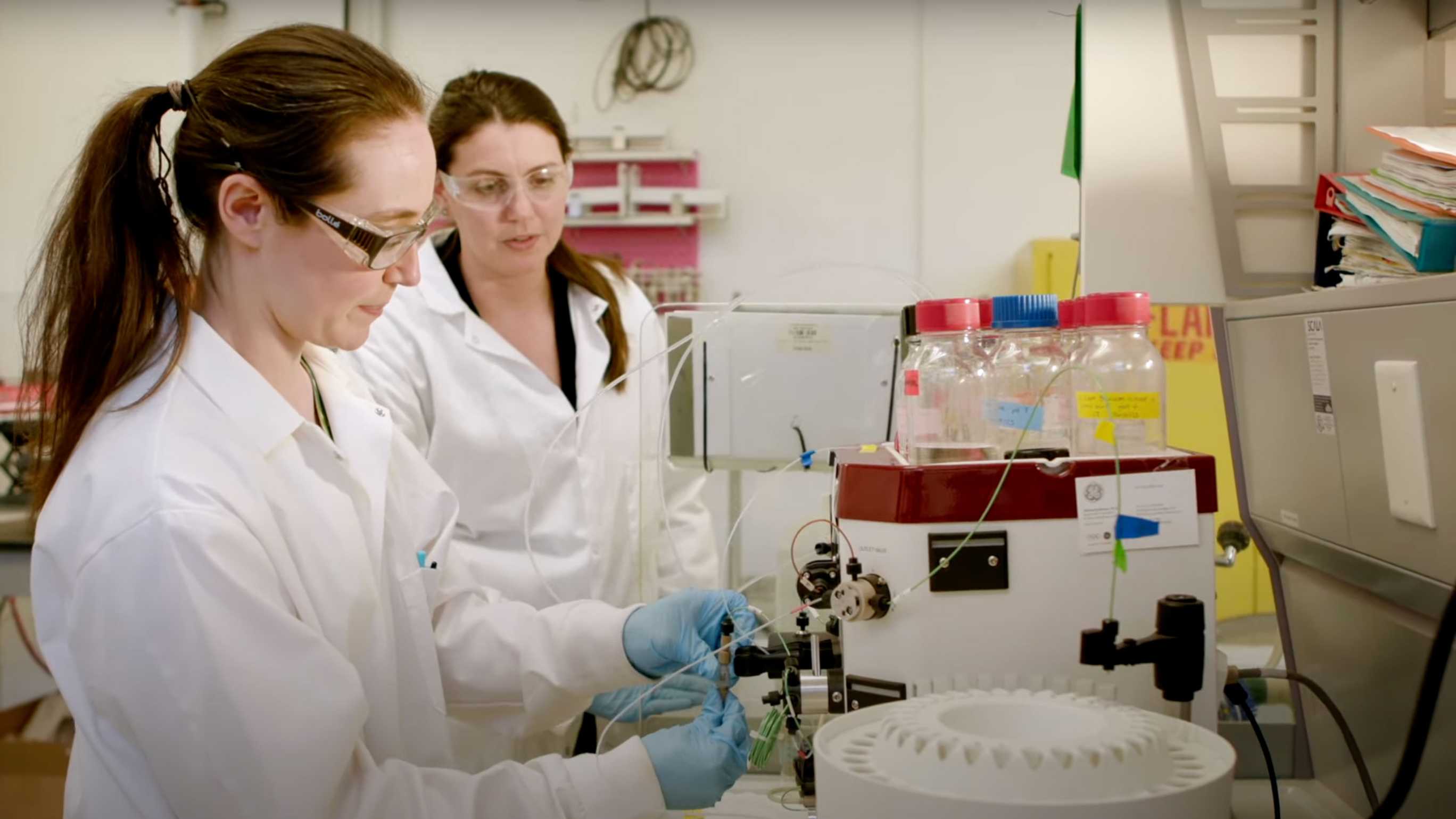 Photo of Christine Duval watching on as a researcher in her lab works on a device
