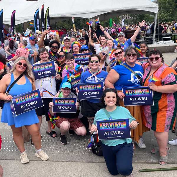 A group of CWRU community members in downtown Cleveland holding a Case Western Reserve University sign at the city’s LGBTQ+ pride event.