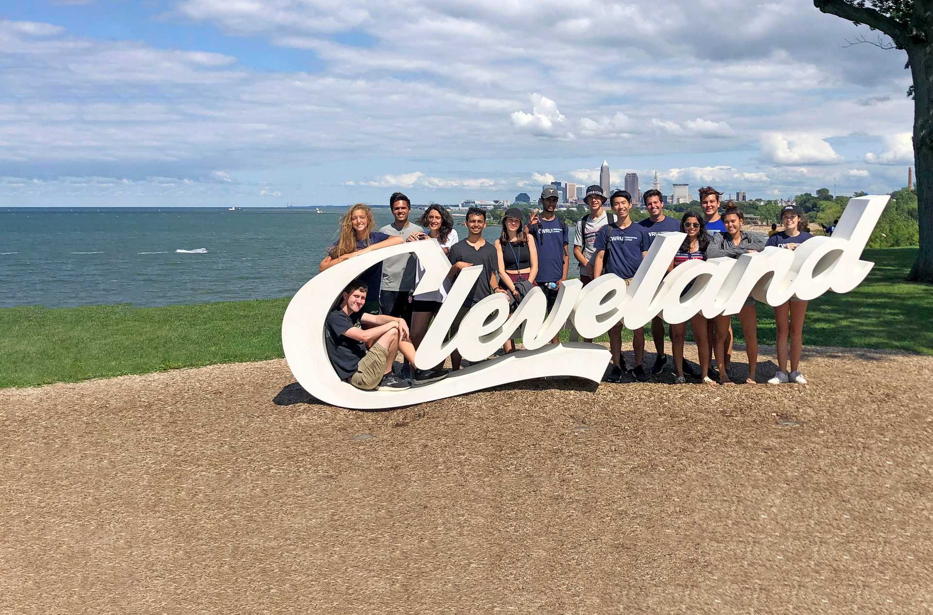 Case Western Reserve University students gather around the Cleveland sign by Lake Erie