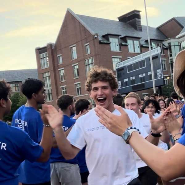 A student running and high-fiving other students.