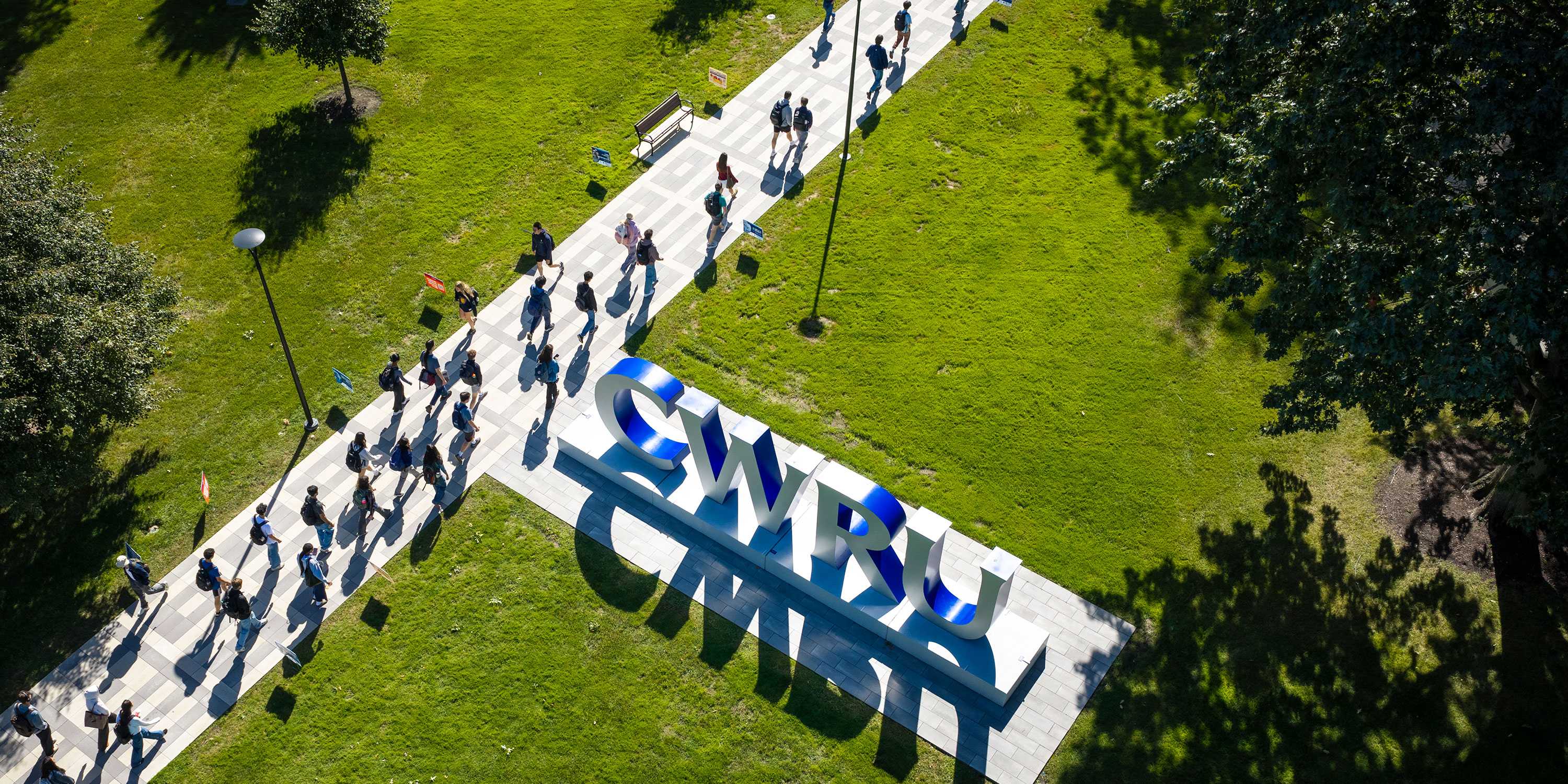 Aerial photo of the CWRU letters with students walking on a wide path