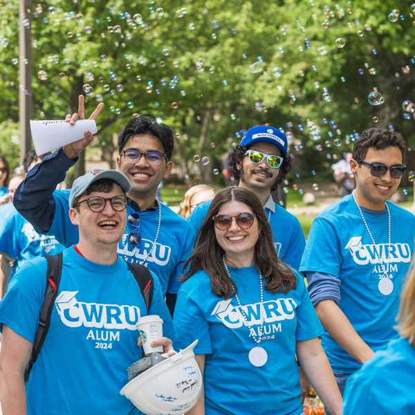A group of 2024 CWRU alumni smiling in the sunshine at last year’s Clap Out celebration.