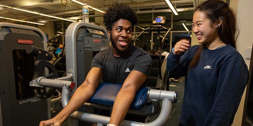 Photo of two Case Western Reserve University students lifting weights in Wyant Athletic Center