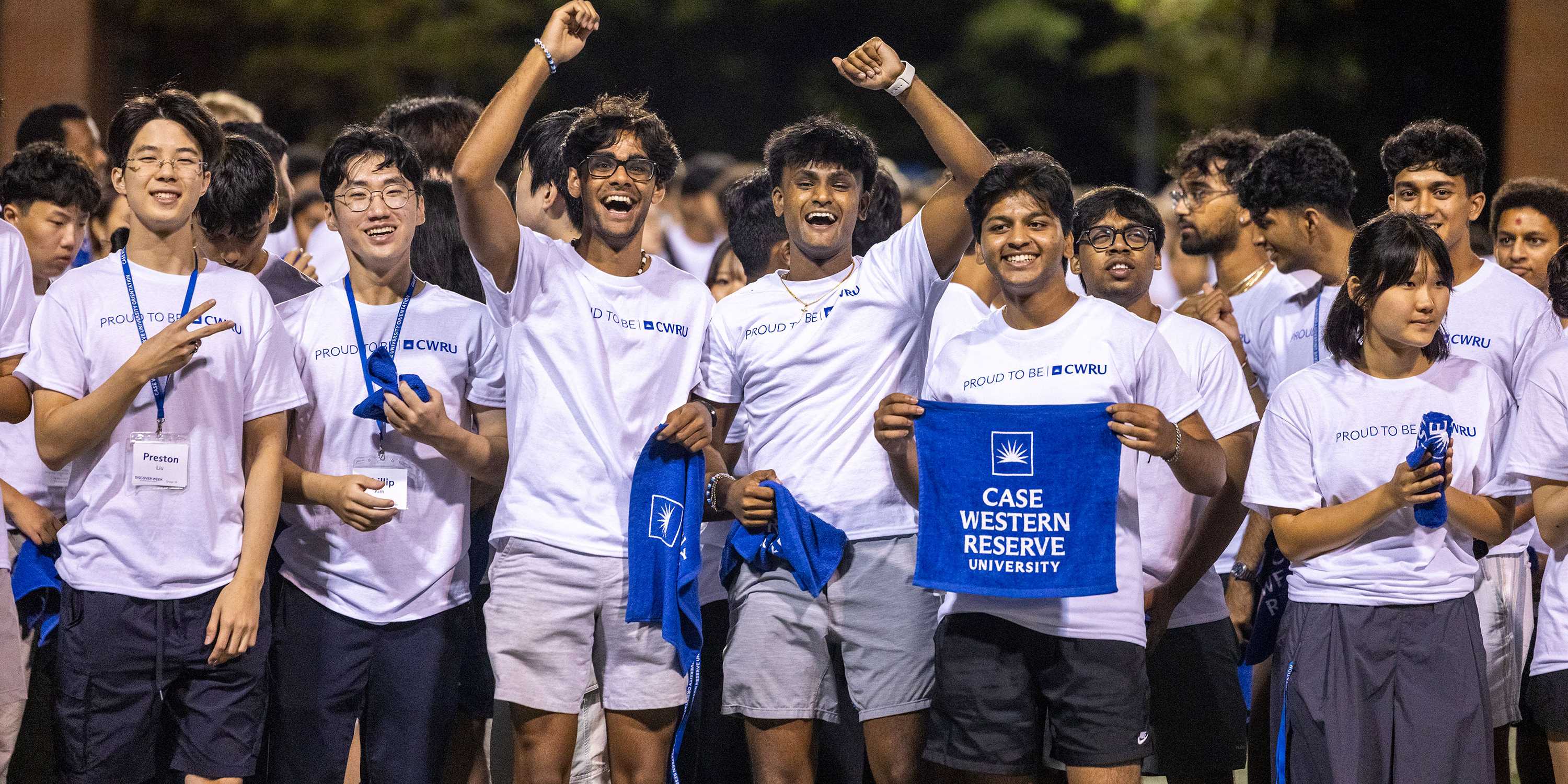 Group of students wearing CWRU white t-shirts and holding CWRU blue rally towels
