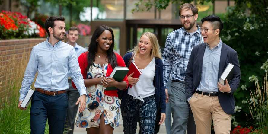 Photo of six Case Western Reserve University School of Law students walking outside, carrying books