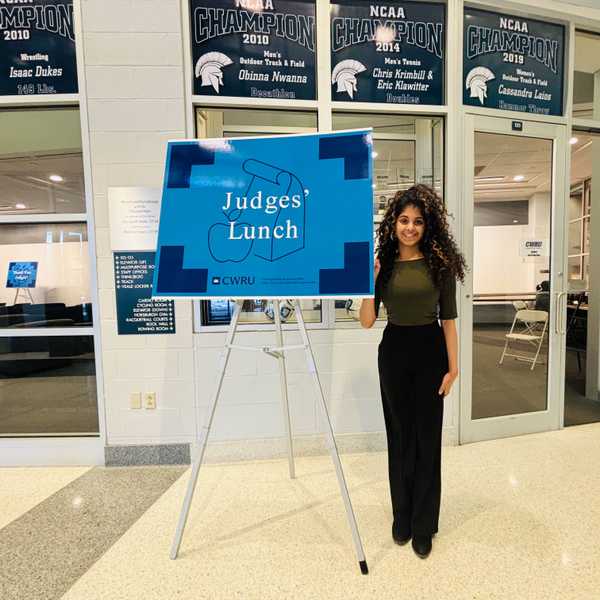 One smiling student posing with a Judge's Lunch sign.