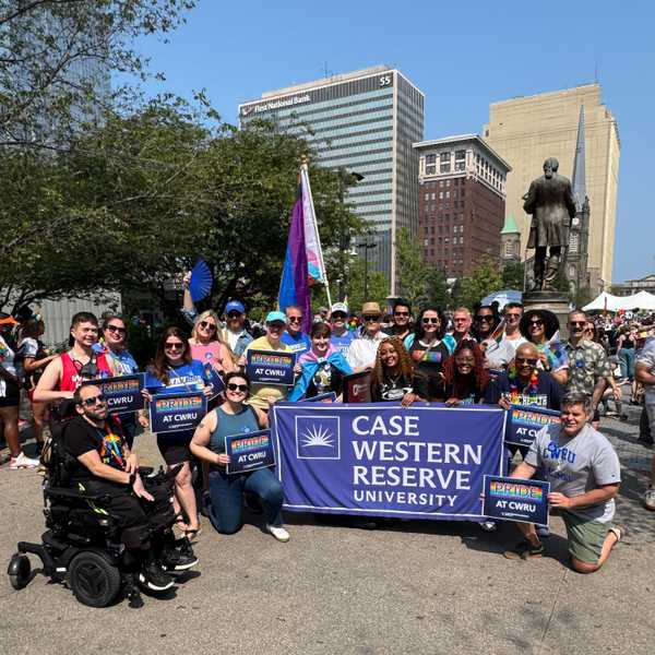 A group of CWRU community members in downtown Cleveland holding a Case Western Reserve University sign at the city’s LGBTQ+ pride event.