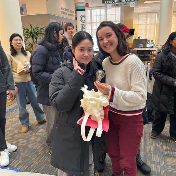 Two CWRU students pose with their successful device from a lightbulb drop competition held in Kelvin Smith Library.