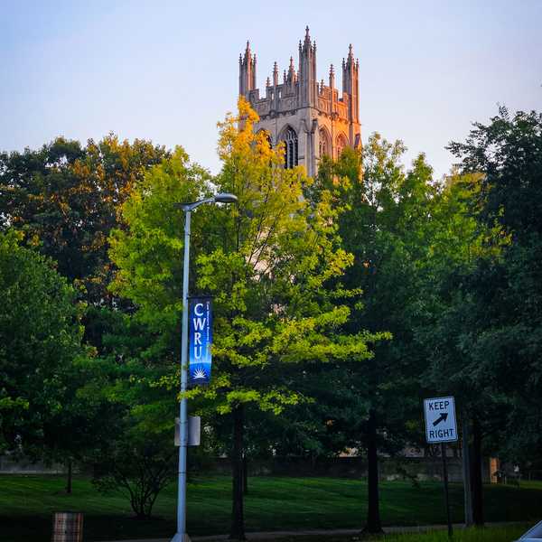 Amasa Stone Chapel peeking out over trees during golden hour.