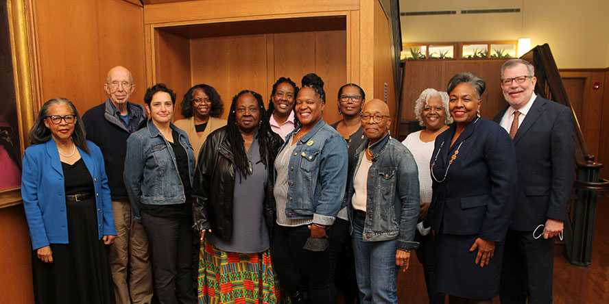 A diverse group of members of the Neighborhood Advisory Council pose alongside CWRU President Eric Kaler inside Adelbert Hall.