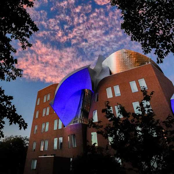 CWRU’s Peter B. Lewis building reflecting blue lights against a dark blue sky with pink clouds.