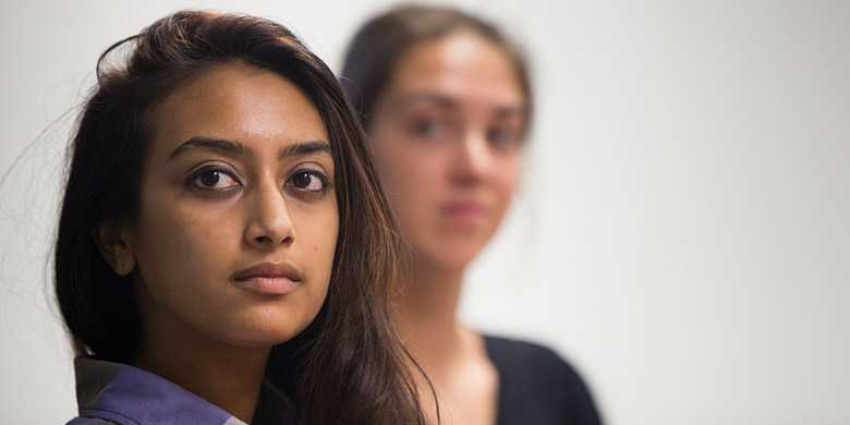 Photo of a Case Western Reserve University student looking at the camera, with another student in the background out of focus