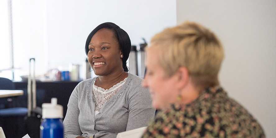 Photo of two individuals in a conference room setting