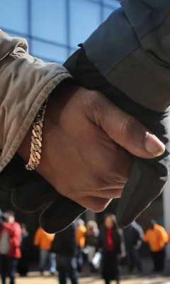 A gloved hand and a not gloved hand holding hands