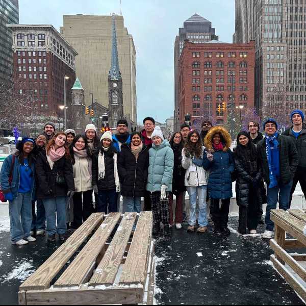 A group of more than 20 CWRU students posing near an ice rink in Cleveland.