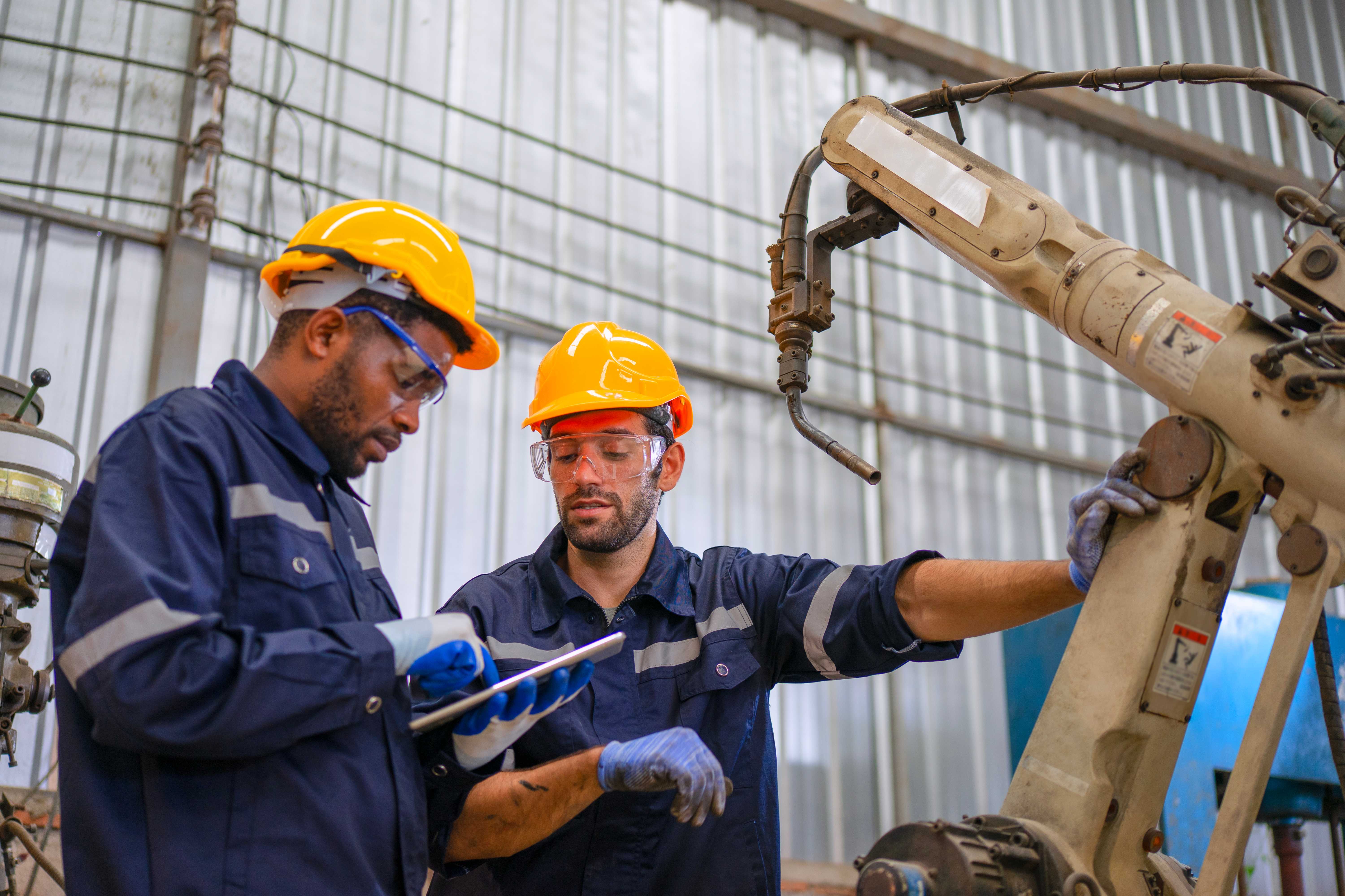 A barge floating down a river with manufacturing plants on the lond beside it