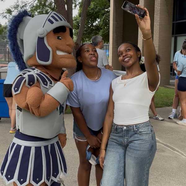 Mascot Spartie poses for a selfie with two CWRU first-year students outside on move-in day.