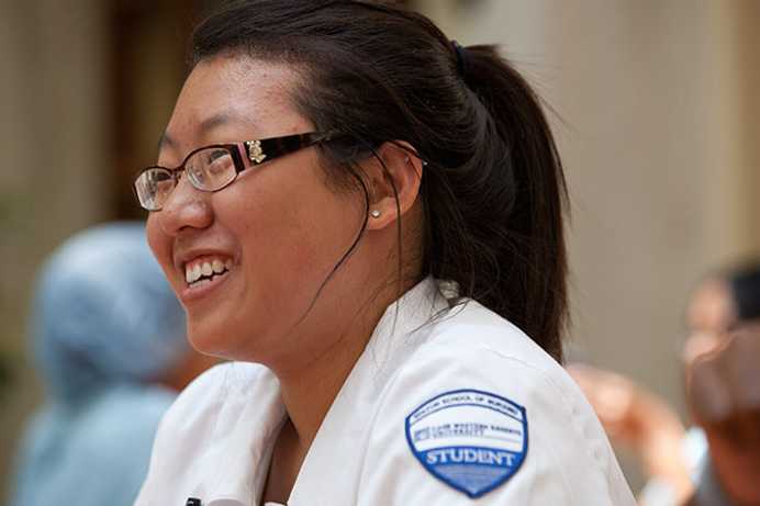 Close-up photo of a Case Western Reserve University nursing student wearing scrubs, smiling