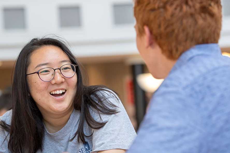 Photo of two Case Western Reserve University students sit talking on a bunk bed in a residence hall