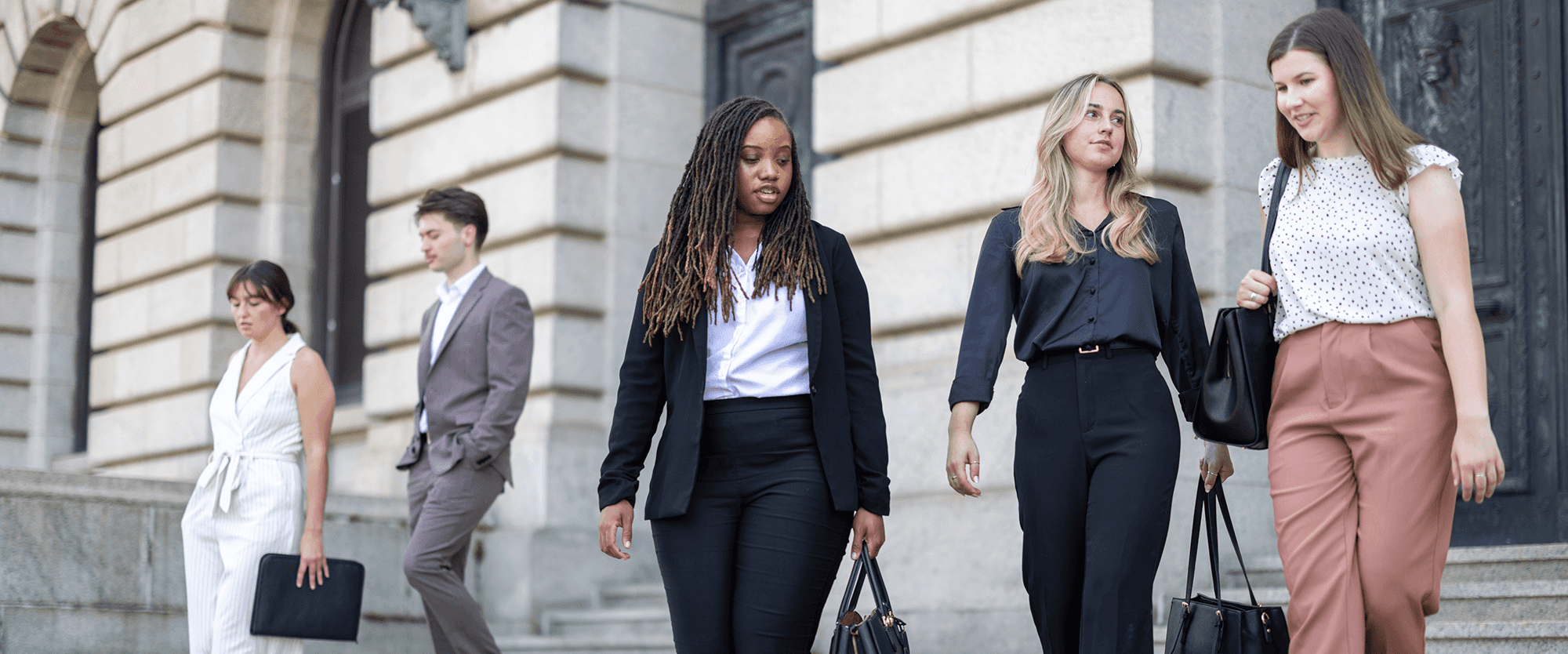 Female law professionals speaking outside of a courthouse