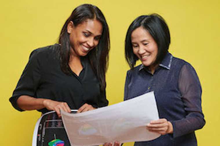 Photo of Case Western Reserve University alumnae Charu Ramanathan and Ping Jia looking at a piece of paper