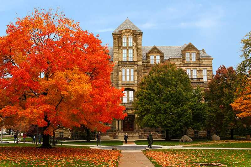 Color photo of Case Western Reserve University’s Adelbert Hall with fall foliage on nearby trees