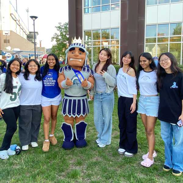 Seven students pose with mascot Spartie outside of DiSanto Field.