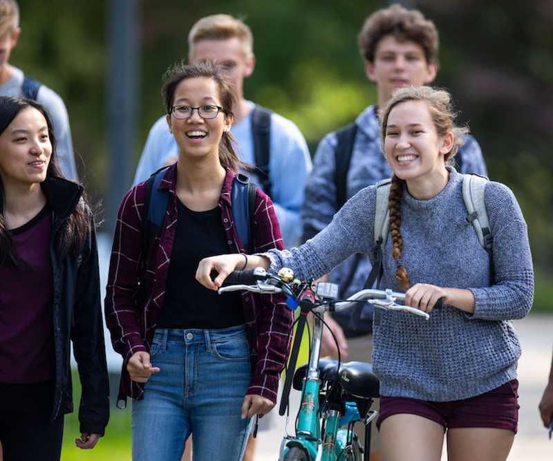 Photo of a group of smiling students walking on the Case Western Reserve University campus