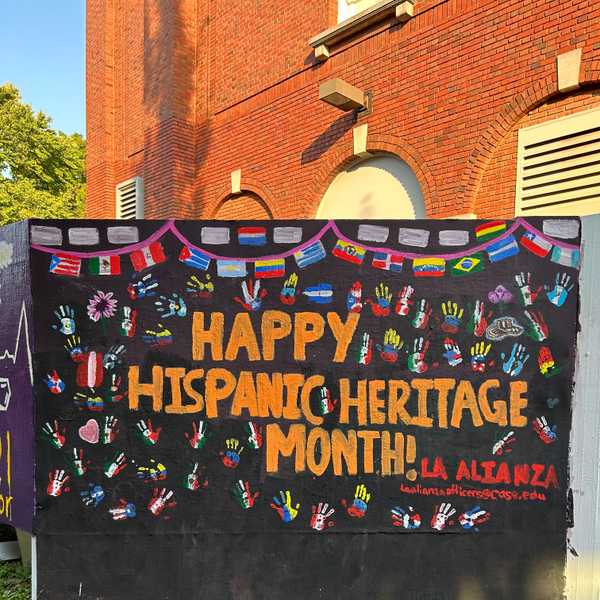 The Spirit Wall outside Tinkham Veale University Center painted with “Happy Hispanic Heritage Month!” and flags of Hispanic countries across the globe.