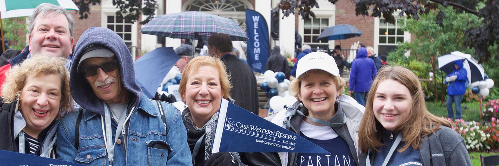 Photo of a group of Case Western Reserve University alumni wearing CWRU clothing and holding pennants 