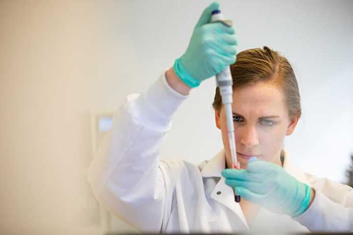 Photo of a Case Western Reserve University student conducting research with a test tube in a School of Medicine lab