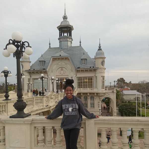 A student smiling for a photo in Argentina while wearing a CWRU sweatshirt.