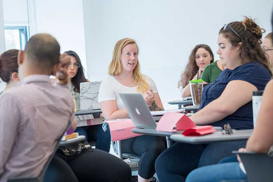 Photo of a Case Western Reserve University classroom with students sitting, engaged in discussion