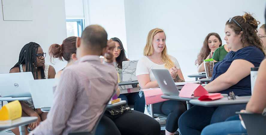 Photo of a Case Western Reserve University classroom with students sitting, engaged in discussion