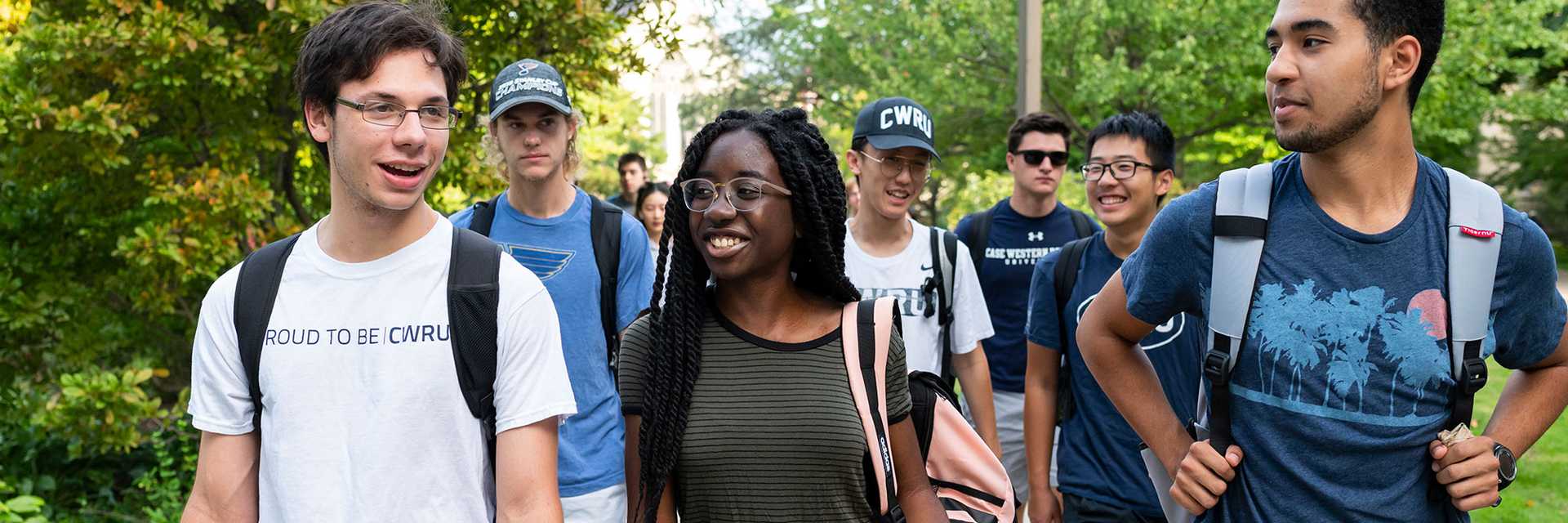A group of Case Western Reserve University students walk outdoors on the quad