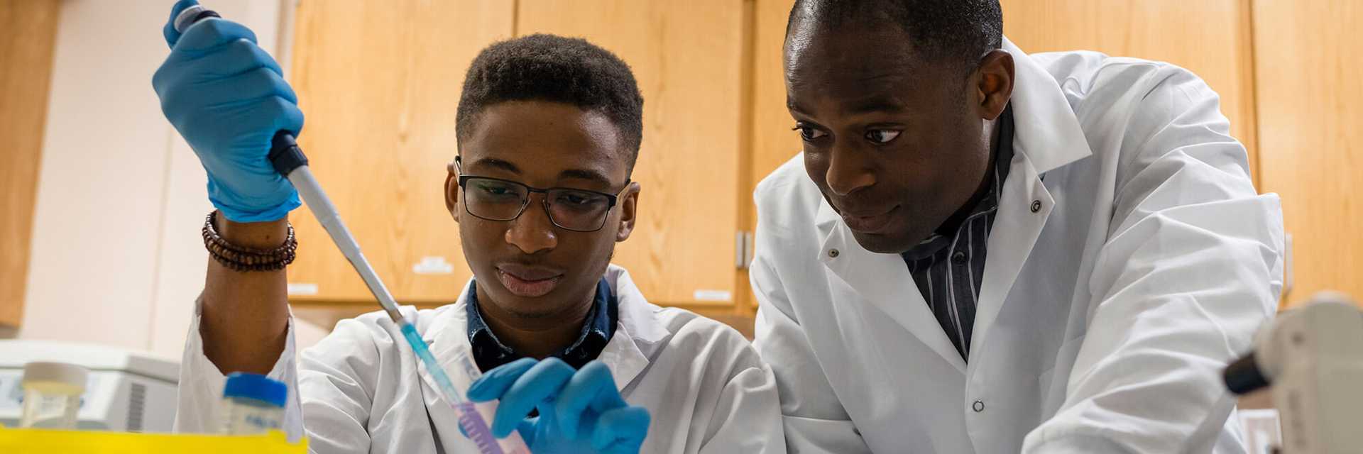 Photo of a Case Western Reserve University student and faculty member conducting engineering research together using a syringe